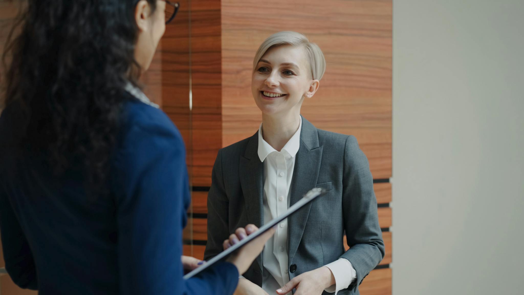 Two professionals having a conversation during a business meeting indoors.